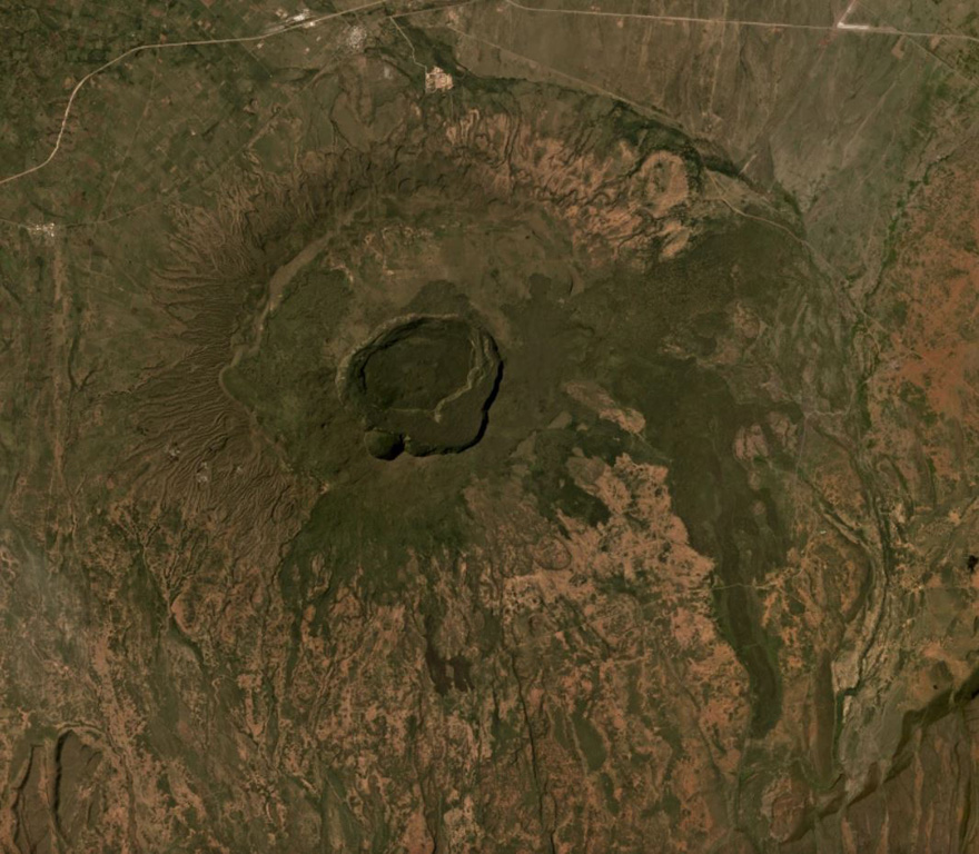 Suswa is the southernmost volcano of the Central Kenya Peralkaline Province (CKPP). The shield volcano has nested summit calderas that are visible in the center of this December 2019 Planet Labs satellite image mosaic (N at the top), with widths of 12 km for the largest caldera and 5.5 km for the inner caldera. More recent lava flows appear darker in this image. Satellite image courtesy of Planet Labs Inc., 2019 (https://www.planet.com/).