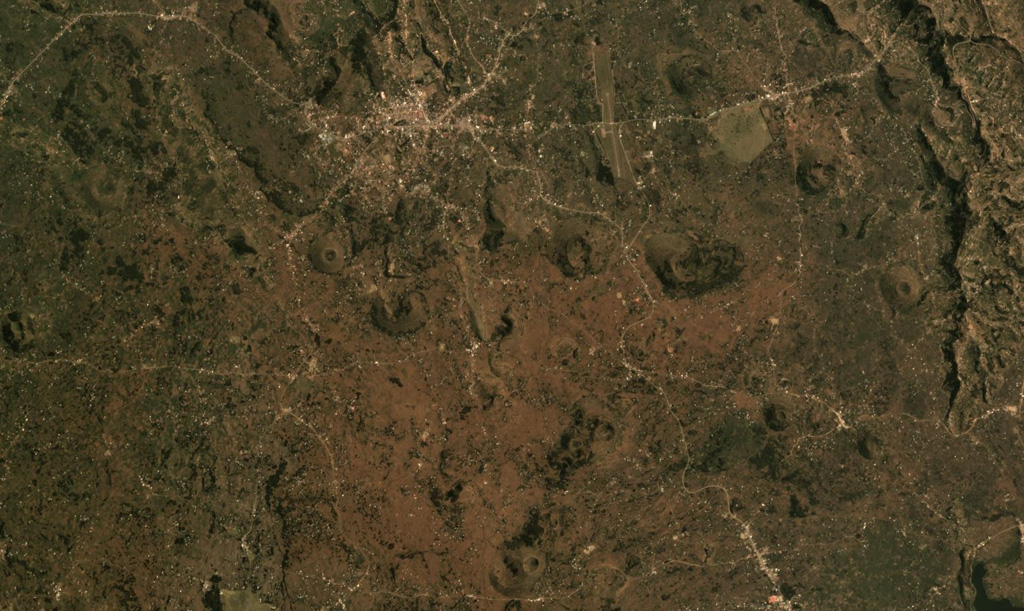 The Bufumbira volcanic field in SW Uganda contains numerous scoria cones including those shown in this August 2019 Planet Labs satellite mosaic (N at the top). The field is in the Virunga volcanic province in SW Uganda and covers approximately 320 km2 with Muhavura, Mgahinga, and Sabinyo along the southern boundary. Several of the scoria cones near the center of this image produced lava flows through the collapse of a flank, resulting in horseshoe-shaped edifices. Satellite image courtesy of Planet Labs Inc., 2019 (https://www.planet.com/).