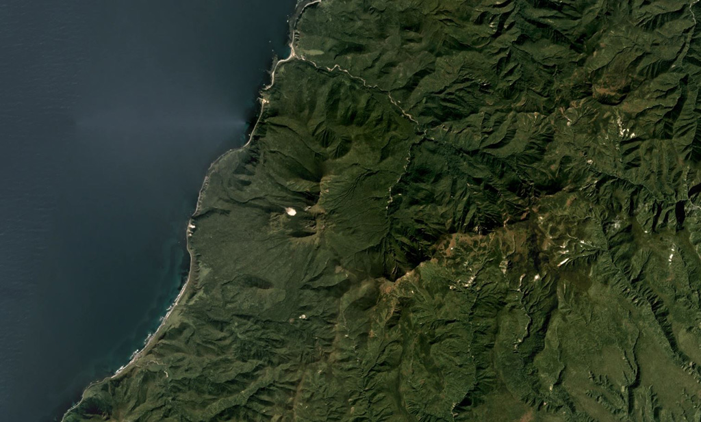 Tri Sestry volcano has an eroded edifice consisting of the Tri Sestry cone with a lava dome at the summit and a 1-km-diameter crater on the NW slope, along with another edifice. The complex is seen here along the coastline of Urup Island, in this September 2019 Planet Labs satellite image mosaic (N is at the top), which is approximately 20 km across. Satellite image courtesy of Planet Labs Inc., 2019 (https://www.planet.com/).