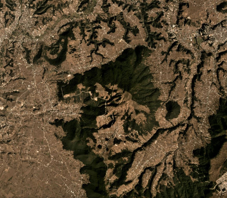 Cuxliquel volcano forms the triangular vegetated area in the center of this Planet Labs December 2019 satellite image monthly mosaic (N is at the top; the image is approximately 10 km across). The smaller vegetated area to the E is the Cerro de Oro lava dome. The surrounding area is the city of Quetzaltenango. Satellite image courtesy of Planet Labs Inc., 2019 (https://www.planet.com/).
