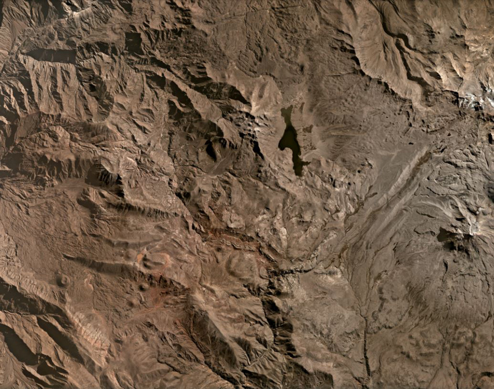Several scoria cones of the Huambo volcanic field are visible in this July 2020 Planet Labs satellite image monthly mosaic (N is at the top; the image is approximately 40 km across). It has a northern and a southern field and contains up to 60 cones that span 300 to 1,200 m in diameter and up to 300 m in height. The upper area of this image N of the lake contains lava flows erupted from Cerro Keyocc the northern part of the field.  Satellite image courtesy of Planet Labs Inc., 2020 (https://www.planet.com/).