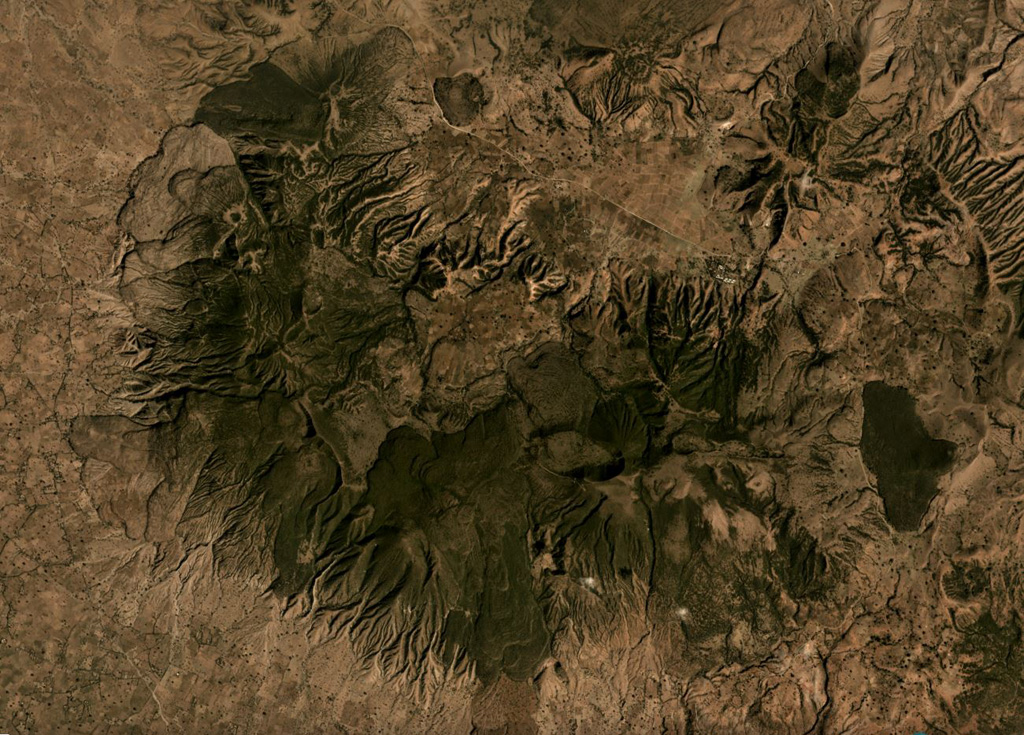 Aluto is a caldera in Ethiopia with features including lava flows, pumice cones, explosive deposits, and 96 identified vents within and around the caldera, shown in this November 2019 satellite image monthly mosaic (N is at the top; this image is approximately 12 km across). Darker obsidian lava flows are visible around the 6 x 9 km caldera. Satellite image courtesy of Planet Labs Inc., 2019 (https://www.planet.com/).