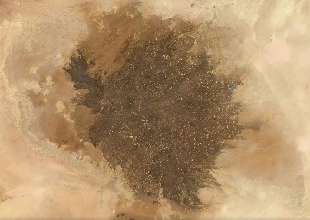 The Al Haruj volcanic province covers around 42,000 km2 in Libya, shown in this November 2019 Planet Labs satellite image monthly mosaic (N is at the top; this image is approximately 350 km across). It contains numerous lava flows, scoria cones, spatter cones, vents including maars, and 47 identified dike segments. Satellite image courtesy of Planet Labs Inc., 2019 (https://www.planet.com/).