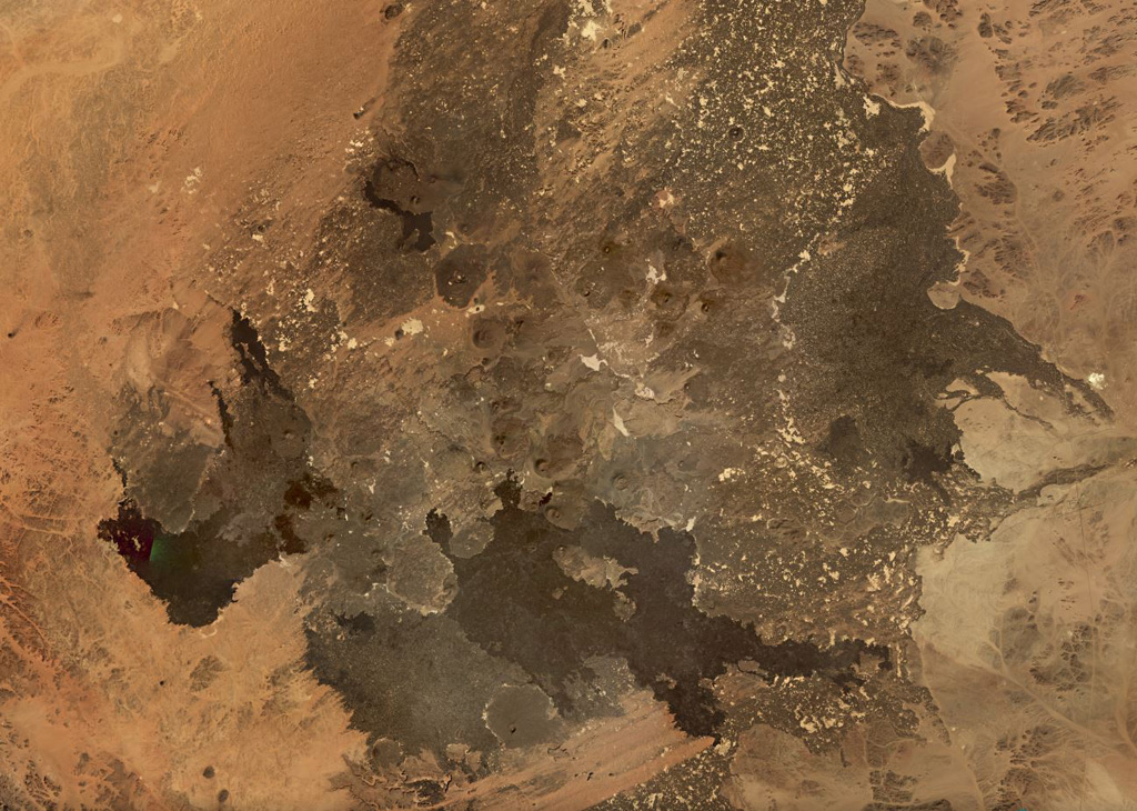 The 4,000 km2 Harrat Ithnayn volcanic field covers much of this November 2019 Planet Labs satellite image monthly mosaic (N is at the top; this image is approximately 94 km across). Scoria cones are visible across the field, with the Jabal Hazam Khadra’ cone is at the bottom of the center of the image. The lava flows are different shades dependending on variable amounts of weathering, erosion, and the amount of sedimentation on the surface. Satellite image courtesy of Planet Labs Inc., 2019 (https://www.planet.com/).