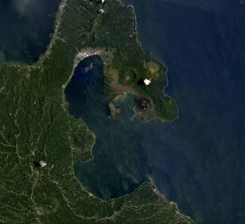 The 8 x 14 km Rabaul caldera is in the center of this September 2018 Planet Labs satellite image monthly mosaic (N is at the top), with several cones that have formed along the perimeter. Tavurvur is the unvegetated cone on the peninsula to the E, then to the NW of that is the crater of Palangiagia. The cone in the middle of the coastline within the harbor is Vulcan. The eroded cone to the north is Tovanumbatir. Satellite image courtesy of Planet Labs Inc., 2018 (https://www.planet.com/).
