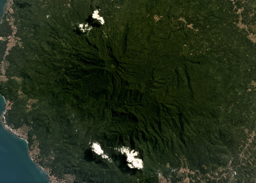 The modern Rajabasa edifice is composed of two edifices, the Rajabasa and Balerang cones, that formed within a 25-km-diameter caldera at the SSE tip of Sumatra Island. The complex is shown in this May 2019 Planet Labs satellite image monthly mosaic (N is at the top; the image is approximately 12 km across). The flanks are formed by lava flows erupted from the summit and flank vents, and flank collapse events have resulted in horseshoe-shaped scarps. Satellite image courtesy of Planet Labs Inc., 2019 (https://www.planet.com/).