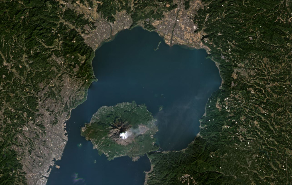 Sakurajima within Aira caldera is producing a gas plume to the NE in this November 2020 Planet Labs satellite image monthly mosaic (N is at the top; this image is approximately 43 km across). The 17 x 23 km caldera formed about 29,000 years ago during the eruption of around 98 km3 of pumice and 300 km3 of pyroclastic flows. In recent times the main epicenter for activity is Sakurajima that has since formed in Kagoshima Bay and is seen here with a weak gas plume dispersing NE to E. Satellite image courtesy of Planet Labs Inc., 2020 (https://www.planet.com/).