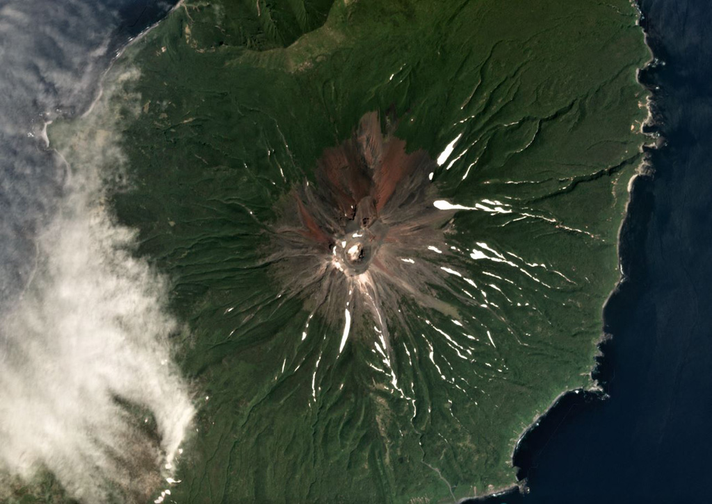 Prevo Peak contains a 450 x 600 m wide summit crater and is located in central Simushir island, shown in this July 2019 Planet Labs satellite image monthly mosaic (N is at the top; this image is approximately 9 km across). Lava flows have been emplaced down the conical flanks and out to both coastlines. Satellite image courtesy of Planet Labs Inc., 2019 (https://www.planet.com/).