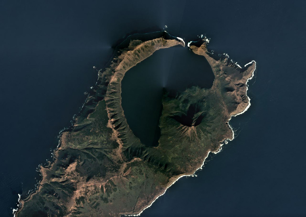 The 7.5-km-wide Pleistocene Uratman caldera containing Brouton Bay and the cone along the SE rim are shown in this October 2018 Planet Labs satellite image monthly mosaic (N is at the top). A lava dome is within the bay and the caldera walls reach up to 450 m in height. Two scoria cones are on the N flank and a lava dome formed on the NW flank. Satellite image courtesy of Planet Labs Inc., 2018 (https://www.planet.com/).