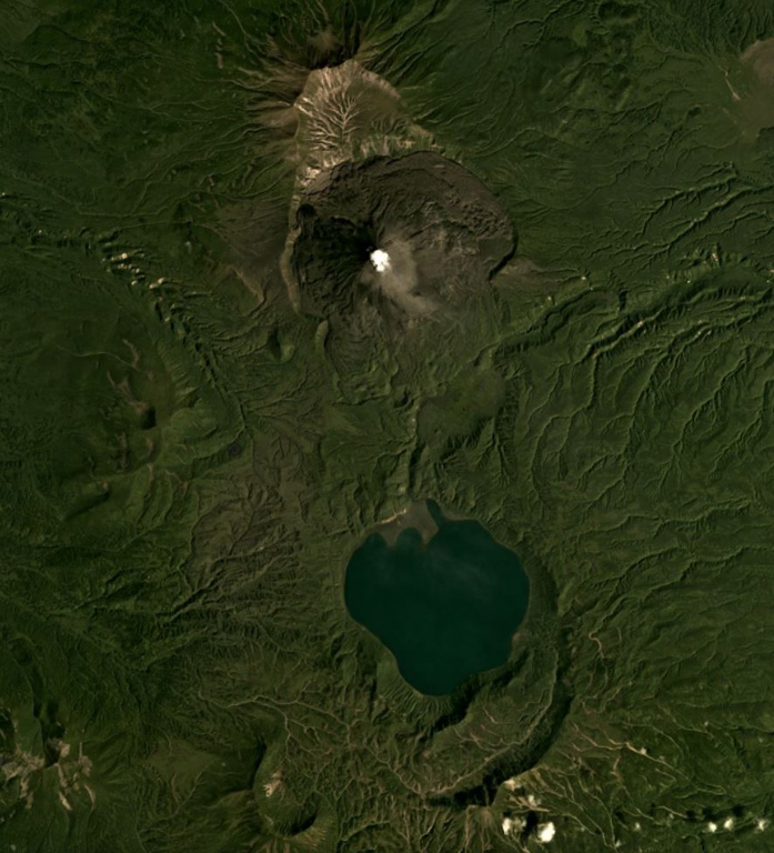 Karymsky is in the north and the Akademia Nauk caldera containing Karymsky Lake is in the south of this August 2019 Planet Labs satellite image monthly mosaic (N is at the top; this image is approximately 19 km across). Along the northern rim of the lake is the 1996 eruption vent, and south of the lake is the Polovinka caldera rim. The current Karymsky cone has formed within the older Karymsky caldera, and adjacent to the northern rim is the Dvor caldera. Satellite image courtesy of Planet Labs Inc., 2019 (https://www.planet.com/).