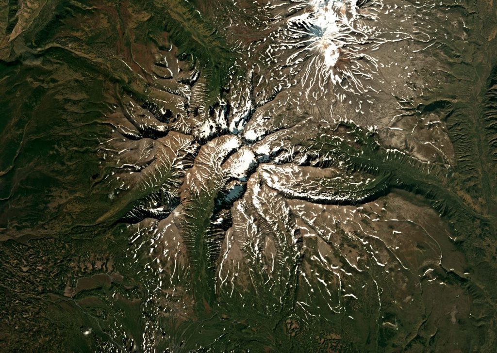 The extensively eroded Schmidt volcano is shown in this September 2019 Planet Labs satellite image monthly mosaic (N is at the top; this image is approximately  33 km across). This was one of the largest early Pleistocene volcanoes in Kamchatka, and after a period of inactivity produced scoria cones on the E and NE flanks during the Holocene. Satellite image courtesy of Planet Labs Inc., 2018 (https://www.planet.com/).