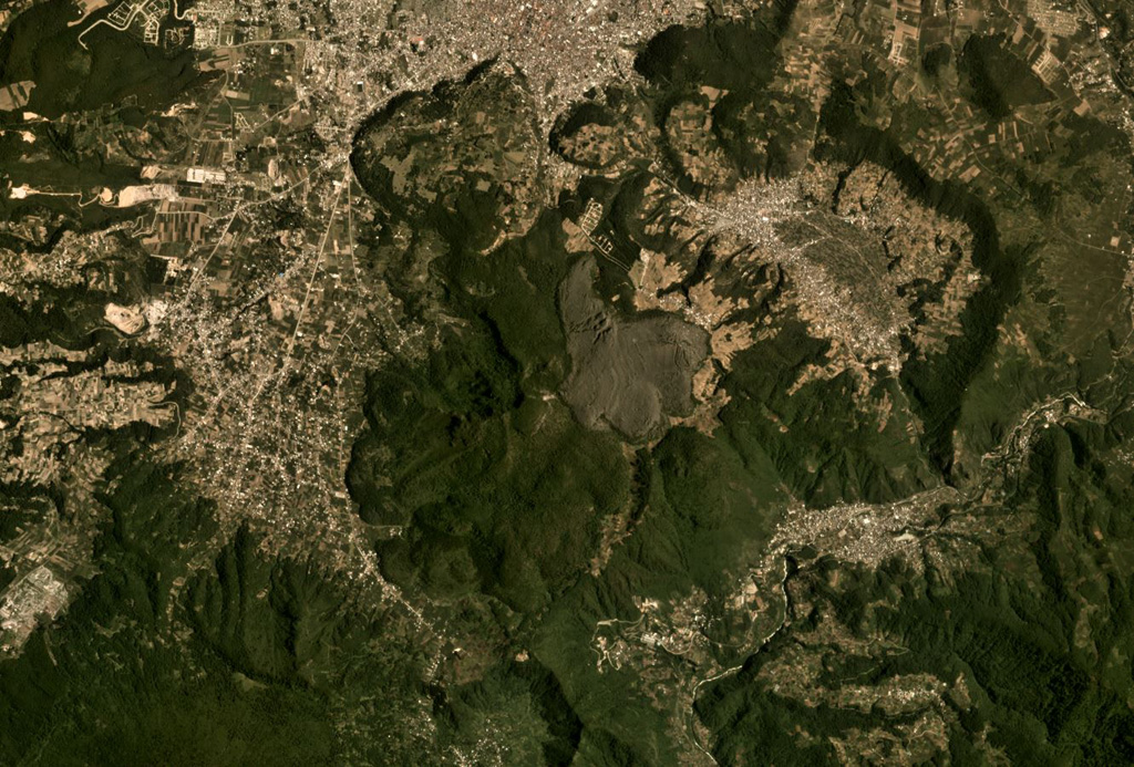Cerro Quemado is a complex of lava domes and flows, including the unvegetated 1818 deposit in the center of this August 2019 Planet Labs satellite image monthly mosaic (N is at the top; this image is approximately 12 km across). It is part of the Almolonga volcanic group that includes the caldera of Volcán de Almolonga to the E and a series of domes to the N. The city of Quetzaltenango is visible to the N. Satellite image courtesy of Planet Labs Inc., 2019 (https://www.planet.com/).