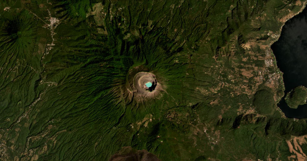 Santa Ana (or Ilamatepec) has several nested summit craters, with the active crater containing the blue lake shown in this February 2021 Planet Labs satellite image monthly mosaic (N is at the top; this image is approximately 16 km across). Several small cones have formed along the SE flank, down to the San Marcelino scoria cone that emplaced the 13-km-long lava flow eastwards in 1722. The Coatepeque Caldera is to the E and the Apaneca Range is to the W. Satellite image courtesy of Planet Labs Inc., 2021 (https://www.planet.com/).