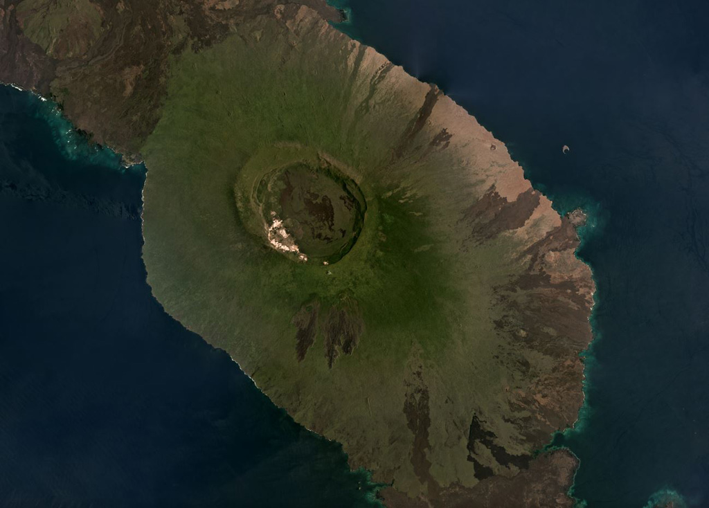The summit caldera of the Alcedo shield volcano, 7-8.5 km in diameter, is near the center of this March 2019 Planet Labs satellite image monthly mosaic (N is at the top). The caldera contains rhyolite lavas, and both rhyolite tephra and pumice have erupted from three identified vents. Radial basalt lava flows form the flanks like the other five volcanoes that make up Isabela Island. The southern flank of Volcán Darwin is to the north and lava flows from Sierra Negra are to the south. Satellite image courtesy of Planet Labs Inc., 2019 (https://www.planet.com/).