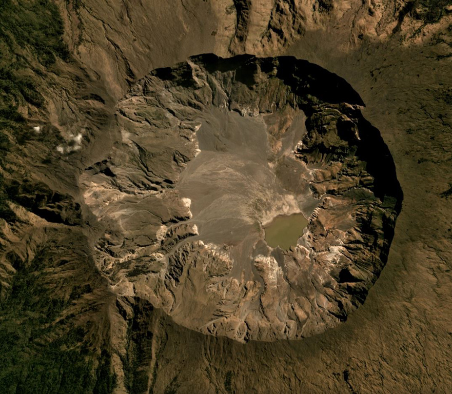 The Tambora caldera formed during the 1815 eruption, after 41 km3 of magma (dense rock equivalent) was expelled, leaving the 6-km-wide and 1-km-deep depression seen in this July 2019 Planet Labs satellite image mosaic (N is to the top). The current area of the caldera is approximately 34.5 km2, with erosion altering the surface and remobilizing material onto the caldera floor. Satellite image courtesy of Planet Labs Inc., 2019 (https://www.planet.com/).