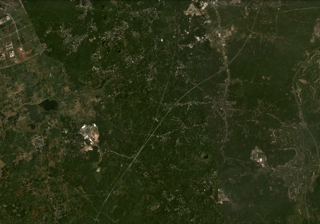 The Hainan Volcanic Field in China contains around 58 identified cones, craters, and maars, some of which are visible in this November 2020 Planet Labs satellite image monthly mosaic (N is at the top; this image is approximately 14 km across). The Leihuling cone with a roughly 300-m-diameter crater is to the SW of the S21 Zhongxian expressway that runs through the center of the image. Satellite image courtesy of Planet Labs Inc., 2020 (https://www.planet.com/).