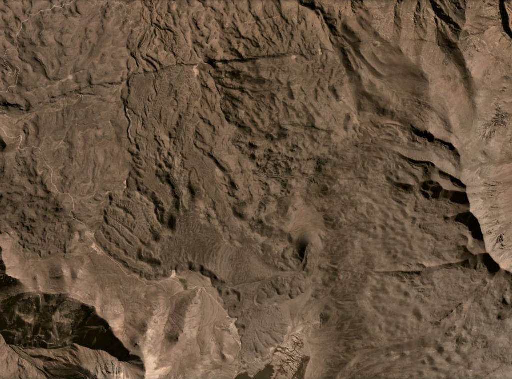 The Cerro Keyocc cone of the northern Huambo volcanic field is shown below the center of this July 2020 Planet Labs satellite image monthly mosaic (N is at the top; the image is approximately 13 km across). The cone produced a lava flow that traveled down the south of the cone then W, then N. The flow has many lobate breakout flows with pressure ridges along the surfaces. Satellite image courtesy of Planet Labs Inc., 2020 (https://www.planet.com/).
