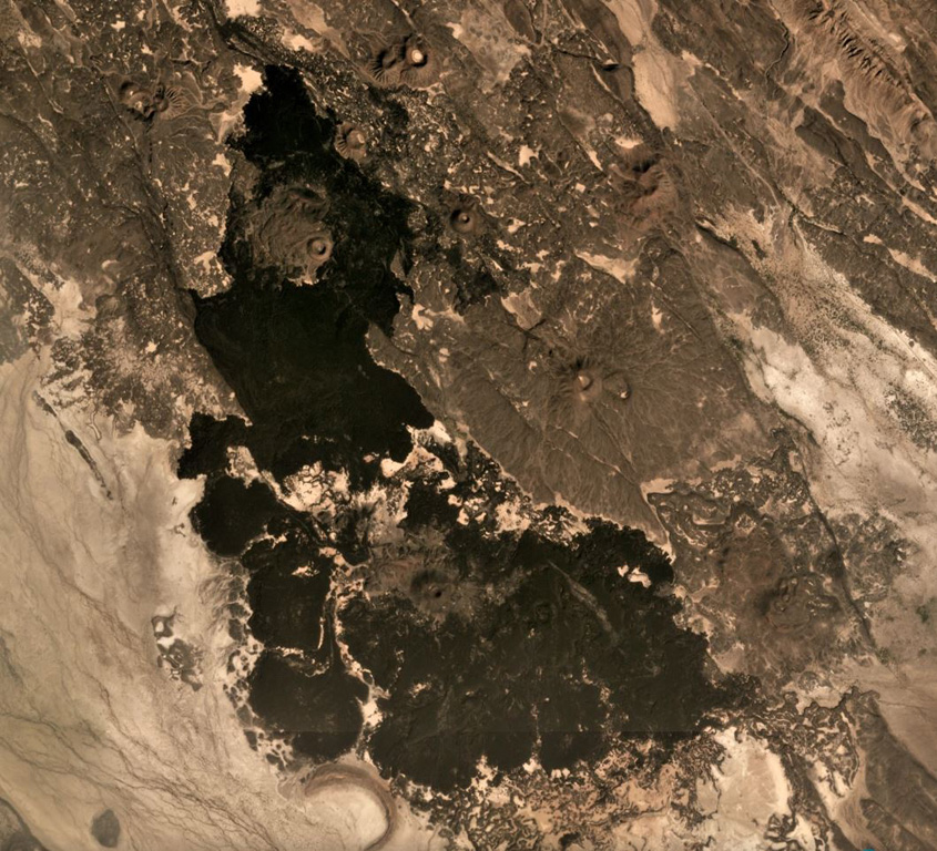 Scoria cones and lava flows of the Manda Gargori rift are seen across this December 2019 Planet Labs satellite image monthly mosaic (N is at the top; this image is approximately 9.5 km across).The rift is one of the younger segments in the Red Sea area and NW-SE trending faults are visible through the image. Ridges of older lava flows are visible between the lighter-colored sediment. A tuff ring is visible south of the younger lavas. Satellite image courtesy of Planet Labs Inc., 2019 (https://www.planet.com/).