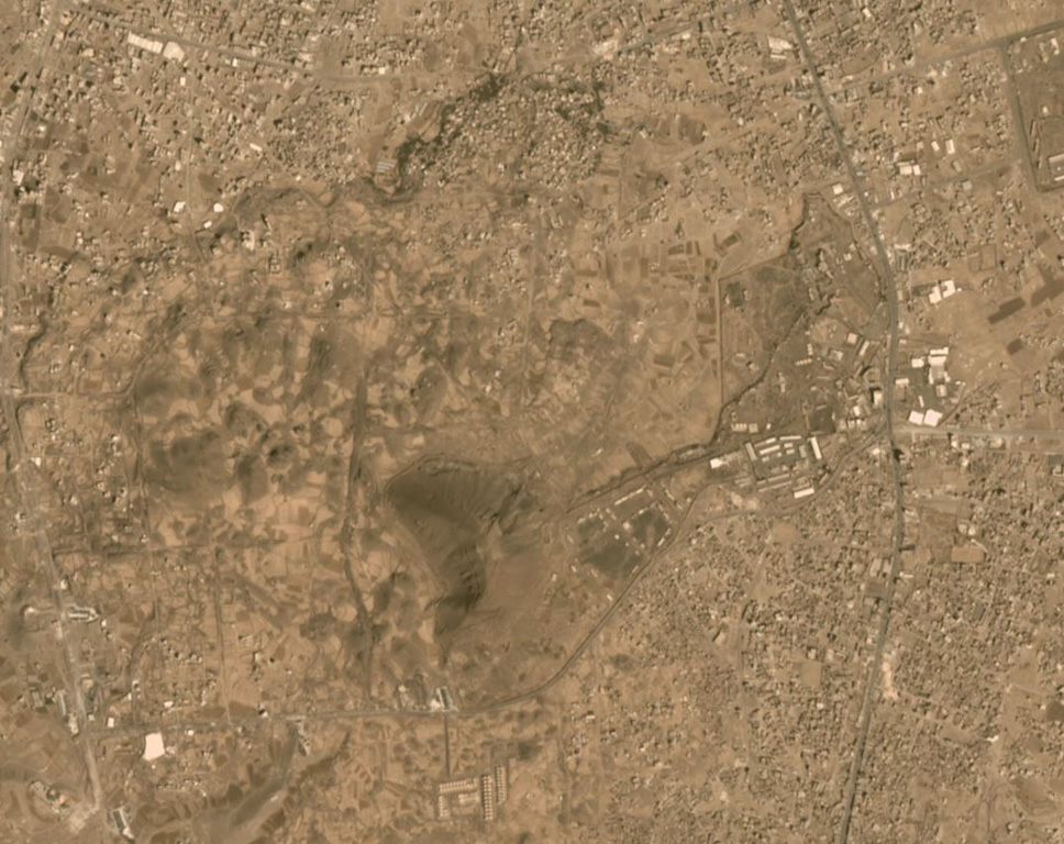 An eroded scoria cone of Jabal el-Marha is near the center of this January 2019 Planet Labs satellite image monthly mosaic (N is at the top; this image is approximately 5 km across). The underlying lava flow morphology is visible, especially along the NW of the image, and reached around 2 km from the cone. Satellite image courtesy of Planet Labs Inc., 2019 (https://www.planet.com/).