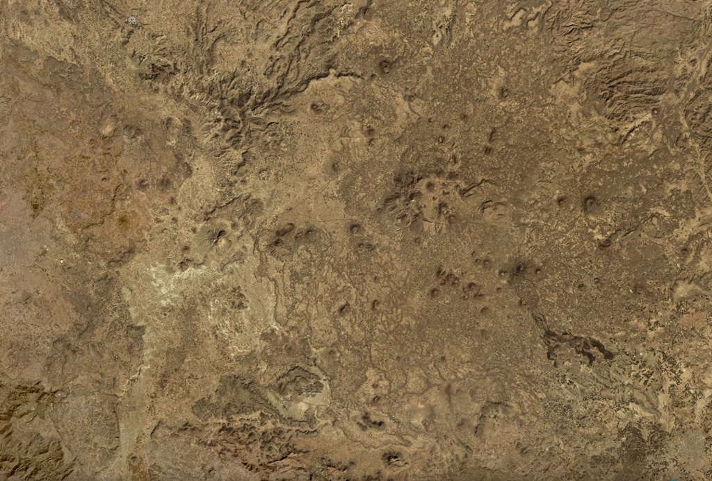 The Harras of Dhamar volcanic field is shown in this December 2019 Planet Labs satellite image monthly mosaic (N is at the top; this image is approximately 51 km across). The field contains many scoria cones and associated lava flows, with some older obsidian lava flows. Many of the cones have amphitheater-shaped craters due to flank collapse or rafting. Satellite image courtesy of Planet Labs Inc., 2019 (https://www.planet.com/).