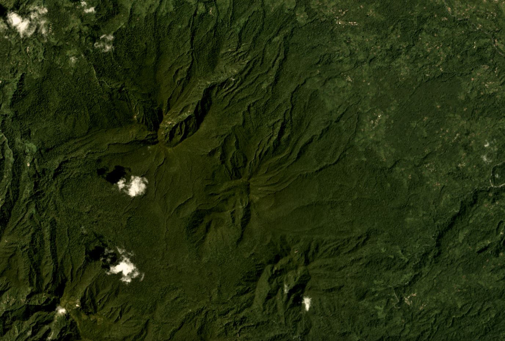 The Takuan Group in southern Bougainville Island, Papua New Guinea, is shown in this Planet Labs satellite image monthly mosaic (N is at the top; this image is approximately 12.5 km across). The group contains three edifices along a NW-SE trend, all of which have probable collapse scarps, and erosion on the flanks. The volcano in the center has a lava dome that has formed within the scarp. Satellite image courtesy of Planet Labs Inc., 2018 (https://www.planet.com/).