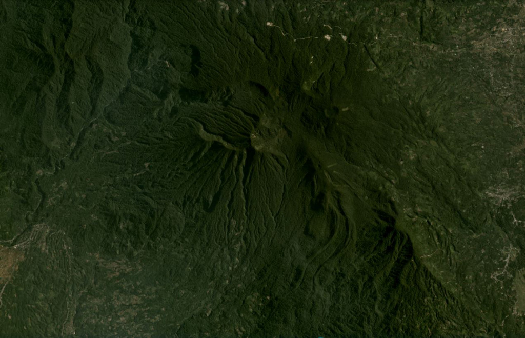 Bukit Daun has a complex summit with several peaks, and a possible landslide scarp on the upper western flank, seen in this August 2020 Planet Labs satellite image monthly mosaic (N is at the top; this image is approximately 22 km across). A crater on the eastern side of the summit area contains Telapak lake and to the south is a lava flow with levees and pressure ridges visible through the vegetation. Satellite image courtesy of Planet Labs Inc., 2020 (https://www.planet.com/).