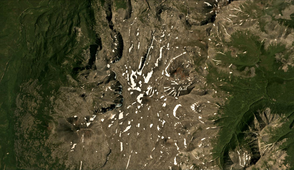A small cone forms the summit of the 72 km2 Kozyrevsky edifice, near the center of this July 2019 Planet Labs satellite image monthly mosaic (N is at the top; this image is approximately 12.5 km across). Glacial erosion has altered the lower flanks and several younger scoria cones have formed around the edifice. Satellite image courtesy of Planet Labs Inc., 2019 (https://www.planet.com/).