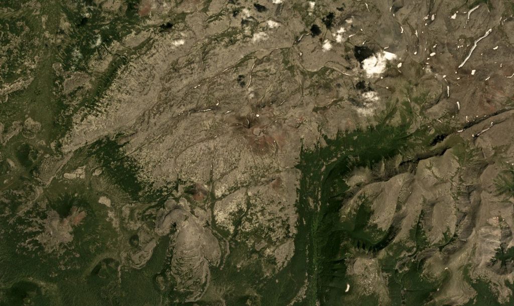 A scoria cone with a summit crater forms the apex of Krainy volcano in the Sredinny Range, Kamchatka Peninsula, in the center of this August 2017 Planet Labs satellite image monthly mosaic (N is at the top; this image is approximately 16 km across). A smaller scoria cone, also red from oxidation, is on the SW flank, beside a roughly 3-km-long lobate lava flow with visible pressure ridges. Satellite image courtesy of Planet Labs Inc., 2017 (https://www.planet.com/).