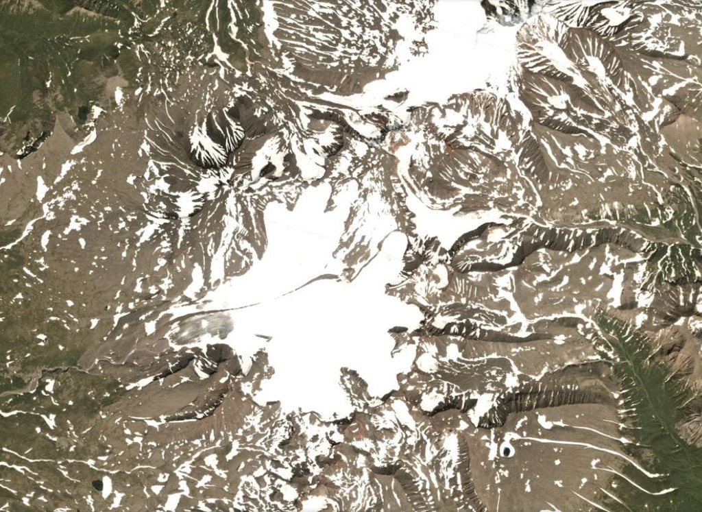 A glacier near the summit of Bely volcano flows down the western flank, shown in this 7 August 2020 PlanetScope satellite image (N is at the top; this image is approximately 21 km across). In relation to the glacier head, to the NW is the Bely cone, NE is Keveneytunup cone, NEE is the Lagerny cone, and SW is Sergeeva, all parts of the Bely complex. The smoother area to the SE with a small crater is Kaileney volcano. Satellite image courtesy of Planet Labs Inc., 2020 (https://www.planet.com/).