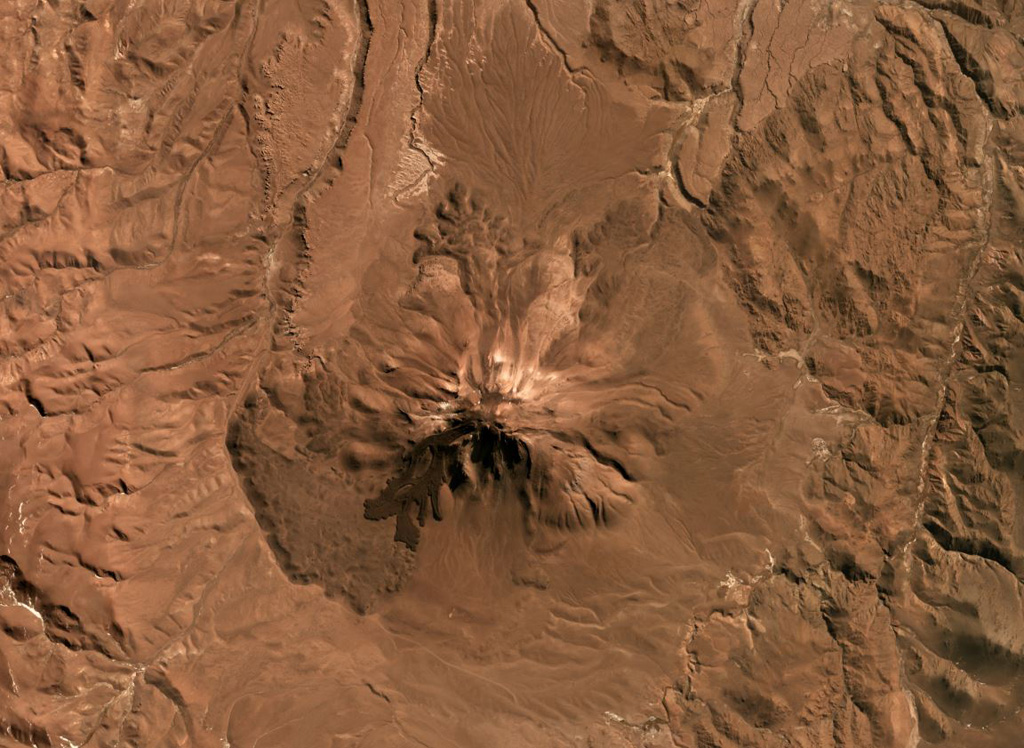 Tuzgle volcano is located in the Puna Plateau, NW Argentina, shown in this July 2019 Planet Labs satellite image monthly mosaic (N is at the top; this image is approximately 20 km across). The flanks are composed of lava flows radially emplaced from the summit, with the youngest flow on the SW and upper N and S flanks, and additional younger flows on the northern and E flanks. Satellite image courtesy of Planet Labs Inc., 2019 (https://www.planet.com/).