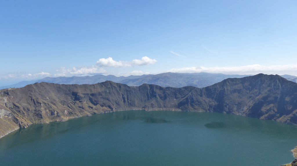 The Quilotoa caldera walls rise around 400 m above the lake, exposing the rocks that formed the previous edifice and intrusions that pushed through them. The high point to the right is the SE lava dome. Bathymetry suggests that several events formed the caldera, with an older and deeper western caldera. Photo by Ailsa Naismith, 2015.