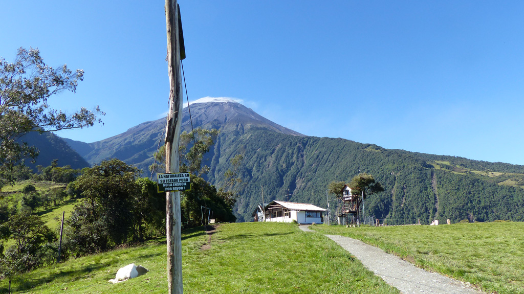 This 3 December 2015 photo shows the Volcán Tungurahua SSW flank from the Casa de Arbol, where IG-EPN operate a seismic station (Runtun). The station is managed by a member of the vigía network, which is a community based monitoring system of volunteers who observe nearby volcanoes and communicate activity to Tungurahua Volcano Observatory volcanologists and local officials. A weak degassing plume is dispersing to the right from the summit, which is also under a small meteorological cloud. Photo by Ailsa Naismith, 2015.