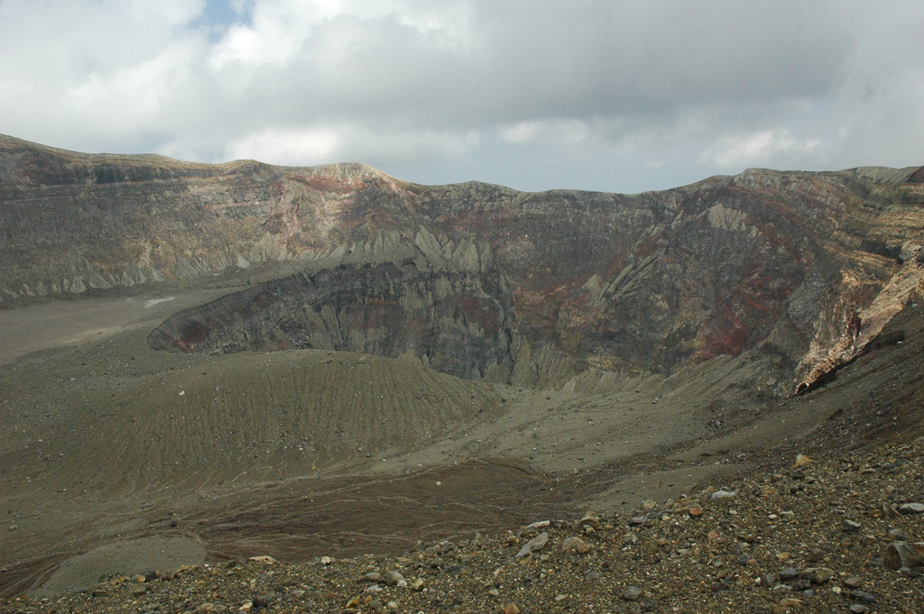 The Santa Ana crater is seen here from the western rim in 2011. Several nested craters have formed across the summit, with a crater lake in the smallest crater in the center of this photo (out of view). Exposed in the crater walls are lava flows and explosive eruption deposits that form the edifice.  Photo by Lis Gallant, 2011.