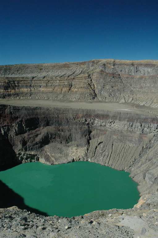 The acidic crater lake of Santa Ana is within the deepest of the nested summit craters, seen here from the S in 2011. The floor of a larger crater is visible across the center of this photo, and both lava flows and deposits from explosive eruptions are exposed in the crater walls.  Photo by Lis Gallant, 2011.