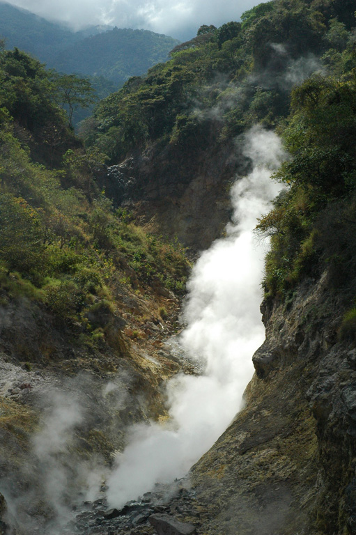 Fumaroles and sulfur deposits on the northern flank of San Vicente (or Chichontepeque) are shown in this 2011 photo. Two geothermal areas are on the N flank, located along two radial faults. These are the surface manifestations of a 12 km2 geothermal reservoir, producing thermal springs and fumaroles. Photo by Lis Gallant, 2011.