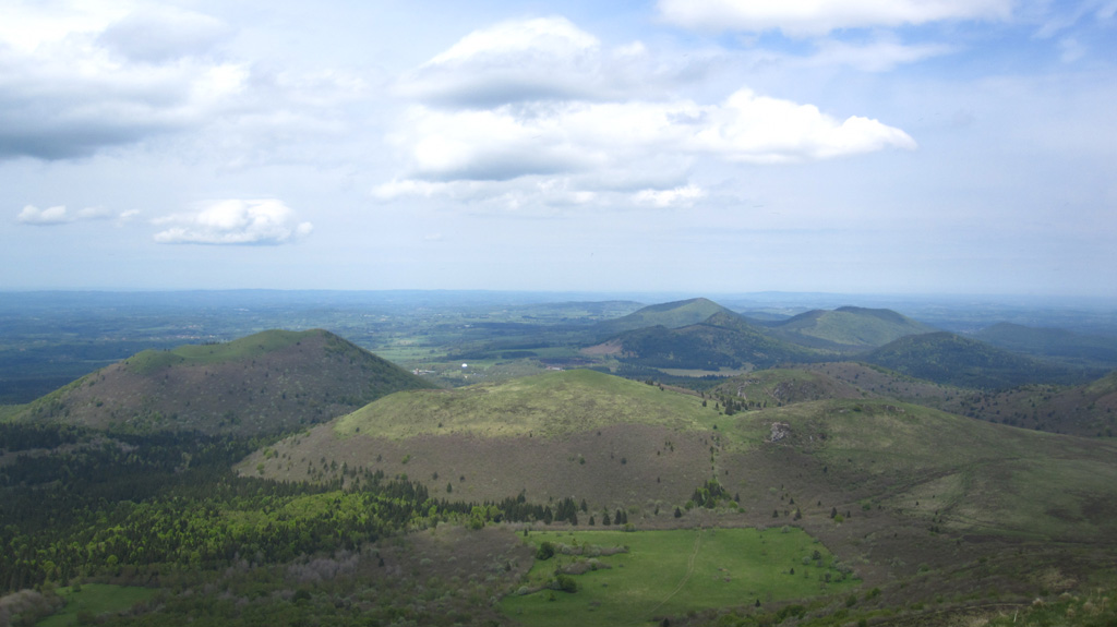 Part of the Chaîne des Puys volcanic field is shown in this May 2016 view from the Puy de Dome. The N-S trending volcanic chain includes around 80 lava domes, scoria cones, and maars, several of which are seen here. Photo by Arianna Soldati, 2016.