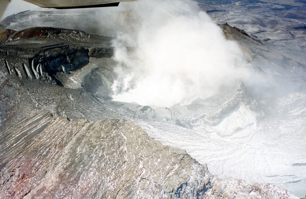 Te Wai a-Moe (Crater Lake) is seen here within the Ruapehu southern crater with little water remaining during the 1995-96 eruption. Ash and ballistics were deposited onto the glaciers around the summit and much of the crater is exposed. The crater dimensions have changed throughout eruptions, with a 1993 publication noting a lake depth of 134 m. In recent times it typically has a lake volume of 9 million m3 (as of January 2022).  Photo by John A Krippner, 1995-1996.