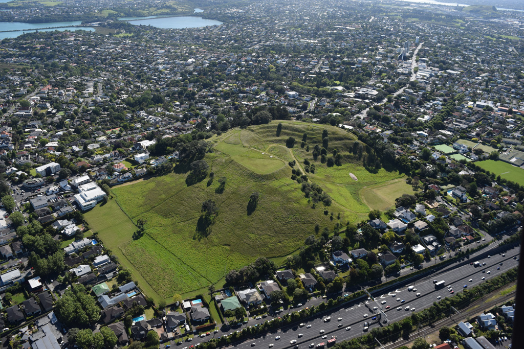 Ōhinerau or Mount Hobson is seen here from the west in 2018. The morphology has been extensively modified by pre-European Māori settlement that was later damaged by quarrying and reservoir construction. Photo by Bruce Hayward, 2018.