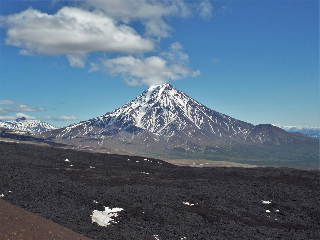 The eroded W flank of Udina is seen here beyond the 2012-13 Tolbachik lava flow. The smaller Malaya Udina is on the opposite side of the cone. Photo by Janine Krippner, 2015.