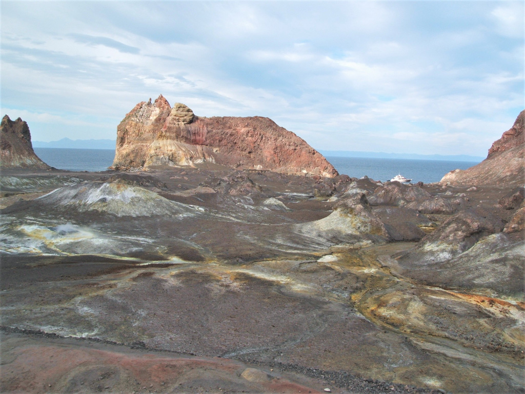 This August 2005 looks across the Whakaari/White Island Eastern Crater towards Troup Head. Across the crater floor are hummocks, 1-3 m high, from the 1914 debris avalanche and hydrothermal alteration products.  Photo by Janine Krippner, 2005.