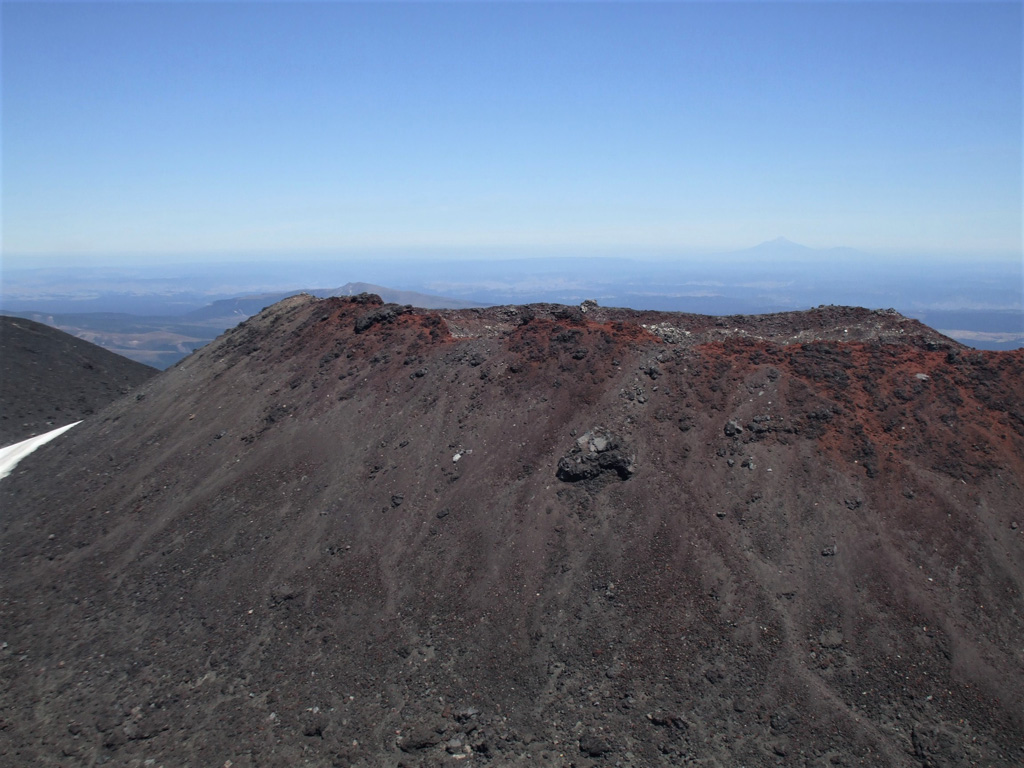 The scoria cone within the Ngauruhoe summit crater largely formed during the 1954-55 eruption and was the location of the 1974-75 eruption, seen here from the larger crater rim to the E. The Ngauruhoe cone is at the southern end of the Tongariro volcanic complex and is one of the youngest features. Taranaki is to the W, visible in the distance. Photo by Janine Krippner, 2008.